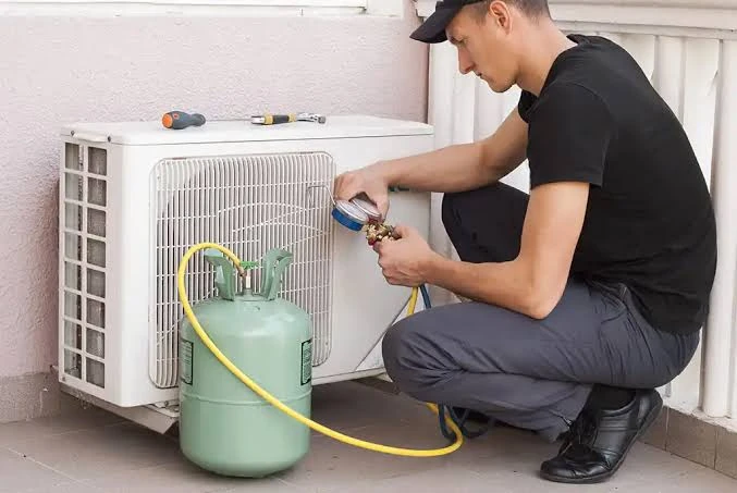 Technician using service gauges with a mini-split outdoor unit